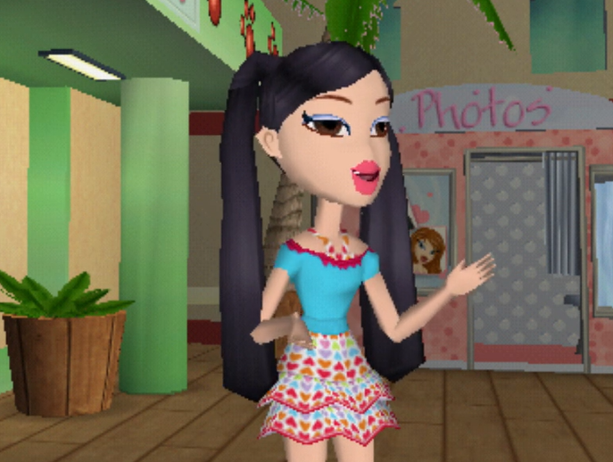 Kumi has long black hair styled into pigtails and brown eyes. She wears a cyan off-the-shoulder top with pink lace at the top over a halter dress with a heart pattern on it. The hearts are red, orange, green, purple blue, and pink. She has pale skin.
